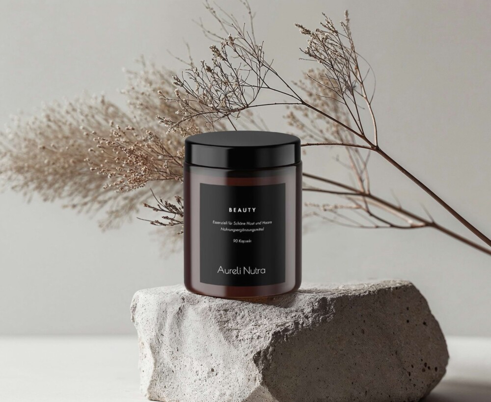 Produktfoto: Aureli Nutra Beauty Dose steht auf einem Stein mit einem Zweig im Hintergrund